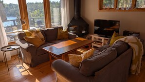 Un salon confortable avec un canapé, une table basse, un téléviseur et une cheminée.