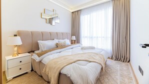 Ein Hotelzimmer mit Bett, Nachttisch, Lampe und einem Spiegel an der Wand.