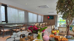 Un espace repas avec des tables, des chaises et une variété de plats et de boissons.