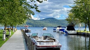 A lakeside dock with boats, a walking path, and a mountain in the background. - Cozy Cabin w/ hot tub, 2 mi from Lake George, 24 acres, fireplace (Hague)