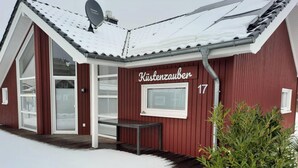 A red building with the name 'Kiistenzauer' and the number 17, a satellite dish, and a bench outside. - Vacation home with trampoline, sauna & fireplace - up to 3 dogs - fully fenced (Schönberg (Holstein))