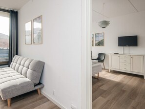 Ett modernt vardagsrum med en soffa, en tv och ett skåp.