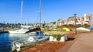 A marina with boats docked, a waterfront promenade, and residential buildings in the background. - Dominica by Interhome (Le Barcarès)