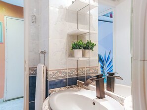 A bathroom with a white sink, a mirror, a towel rack, and a potted plant. - Dominica by Interhome (Le Barcarès)