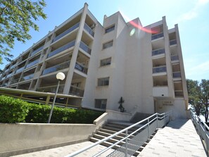 Un immeuble à plusieurs étages doté d’un escalier central, de balcons et d’une enseigne indiquant « CALA DORADA ».