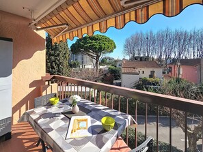 Ein Balkon mit Tisch, Stühlen, einer gelben Schale und einer Zeitschrift.