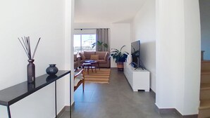 Un salon moderne avec un canapé, une table basse et un meuble pour la télévision.
