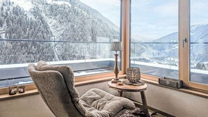 Une pièce dotée d’une grande fenêtre donnant sur des montagnes enneigées.