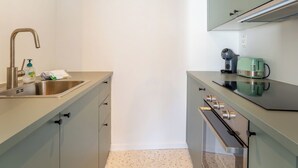 Una cocina compacta con un fregadero, cafetera, tostadora y microondas.