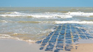 Una playa con olas y un cielo despejado.