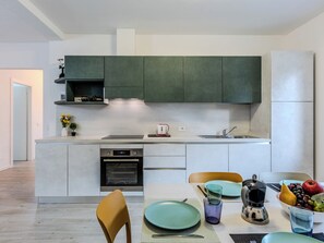 Eine moderne Küche mit Einbauofen, Spüle und Essbereich mit Tisch für zwei Personen.