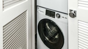 A compact laundry room with two stacked front-loading washing machines.