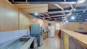 Eine Küche mit Edelstahlgeräten, Holzschränken und einer gefliesten Spritzschutzwand.