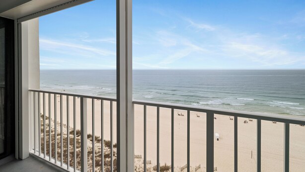 En balkon med udsigt til strand og hav.