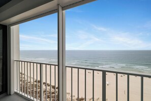 Ein Balkon mit Blick auf Strand und Meer.