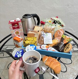 A breakfast tray with pastries, a coffee cup, a teapot, and a milk carton on a table. - B&B 091 (Palermo)
