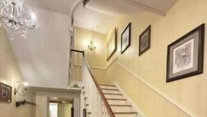 A staircase with white railings and wooden steps, leading to an upper floor. - Langdon Hill House (Gettysburg)