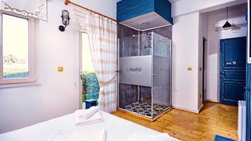 Ein Schlafzimmer mit Bett, Dusche und Blick ins Freie.