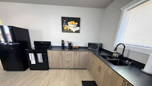 A modern kitchen with a refrigerator, oven, microwave, and sink.