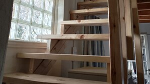A wooden staircase with a window on the left side. - BLUE ESCAPE - Beachfront Privacy for Groups (12+ yrs) (Korission)