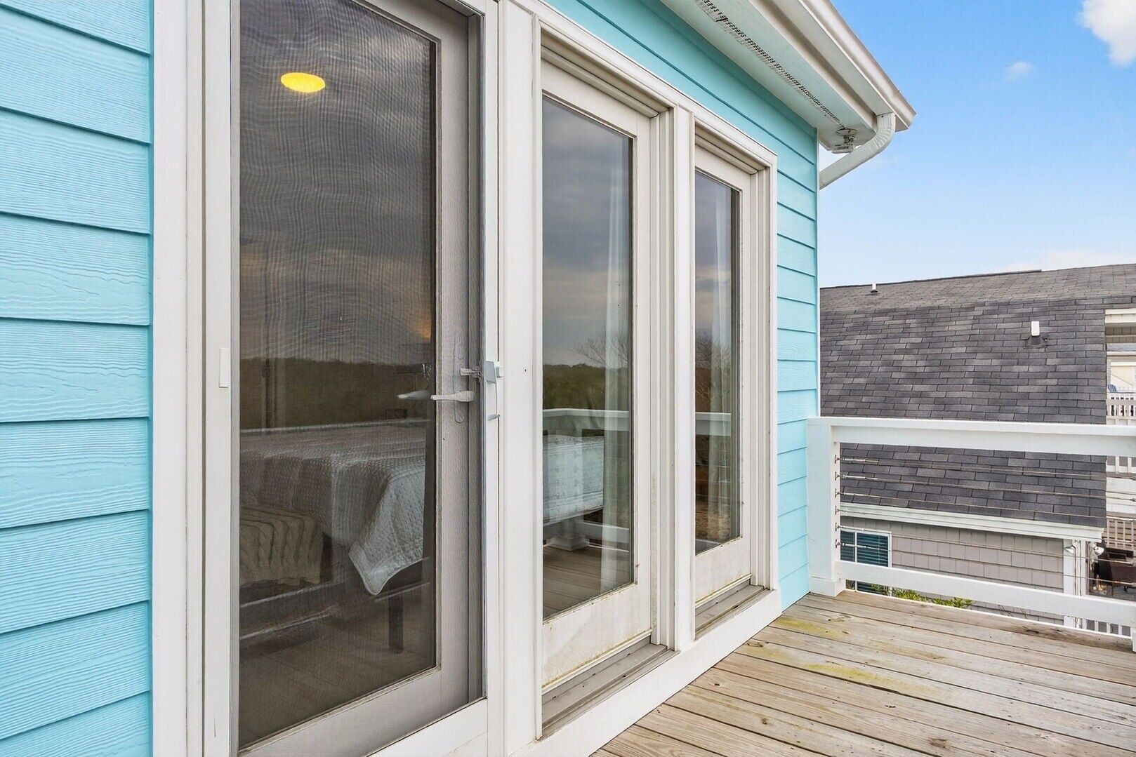 A house with a sliding glass door leading to a covered outdoor area.