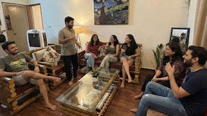 Un salon chaleureux avec une table basse en bois, un tableau au mur et un ventilateur de plafond.