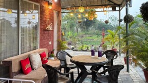 Un espace extérieur aménagé, abrité et doté d’un canapé, de chaises et d’une table.