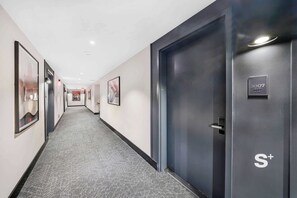 A hotel hallway with framed artwork on the walls, a carpeted floor, and a door labeled '3007 S+'. - Miami Condo | Rooftop Pool | 30th Floor Skyline Views (Miami)