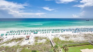 A beach with rows of umbrellas and chairs, a clear sky, and the ocean. - Incredible condo, Newly Renovated Gulf-Front Luxury with Stunning Views. (Destin)