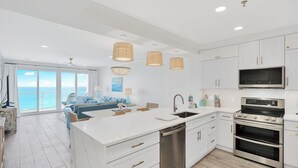 A modern kitchen with white cabinetry, stainless steel appliances, and a large island. - Incredible condo, Newly Renovated Gulf-Front Luxury with Stunning Views. (Destin)