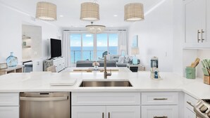 A modern kitchen with a large island, stainless steel appliances, and pendant lighting. - Incredible condo, Newly Renovated Gulf-Front Luxury with Stunning Views. (Destin)