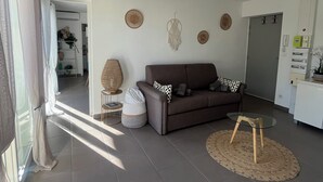 A modern living room with a sofa, a glass coffee table, and a round rug. - Bobo Chic Paradise (Villeneuve-Loubet)