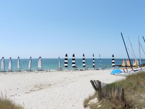 Une plage où l’on peut voir de nombreux voiliers et une clôture en bois.