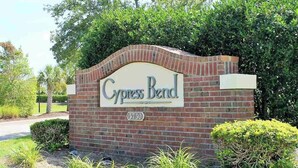 Une enseigne en briques indiquant l’entrée, avec le nom « Cypress Bend » et le numéro de maison « 5750 ».