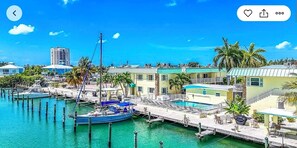 A marina with boats docked, a swimming pool, and buildings with balconies. - Reel Hip!! (Marathon)
