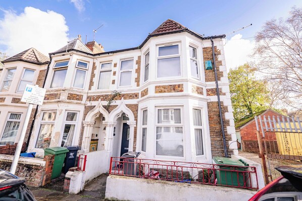 A two-story house with bay windows, a front door, and a small front garden. - Chic 1BR Ground Floor Apartment Near Centre (Cardiff)