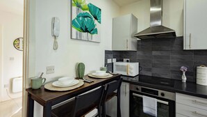Une cuisine moderne équipée d’une table à manger, de chaises, d’un four à micro-ondes, d’un four et de placards.