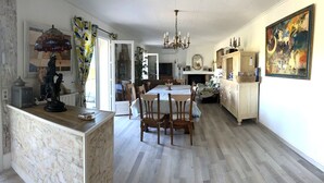 Una cocina amplia con comedor, armarios de madera y una araña.