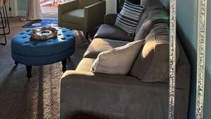 A living room with a sofa, armchair, ottoman, fireplace, TV, and a large mirror. - 1st floor Condo near Lake MI, Saugatuck and  many attraction's.
Heated pool! (Douglas)