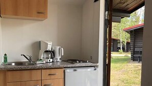 A compact kitchen with a sink, coffee maker, and dishwasher. - Bernsteinsee Home and Ferien Small Forest Chalet (Sassenburg)