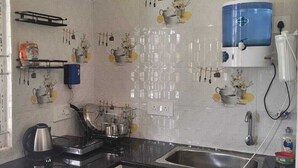 A kitchen with a sink, stove, and various utensils.