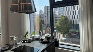Eine Küche mit einem großen Fenster, einem Wasserkocher, einem Mixer und verschiedenen Küchenutensilien.