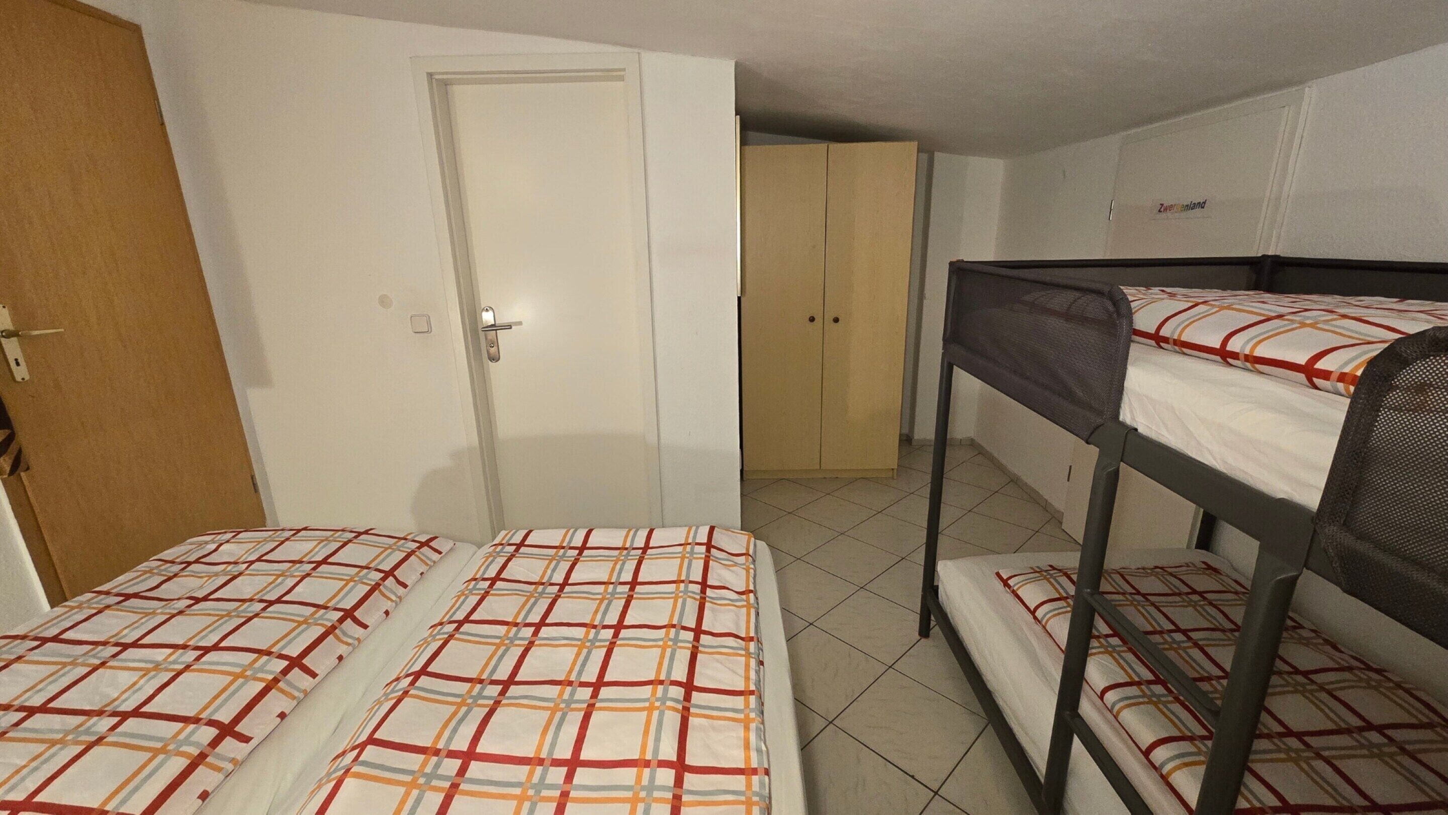 Un dormitorio con literas, una puerta y un armario.