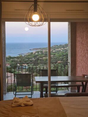 Une chambre avec un balcon donnant sur un paysage côtier.