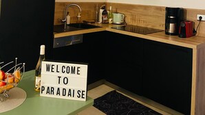 Een moderne keuken met een magnetron, broodrooster, koffiezetapparaat en een welkomstbord.