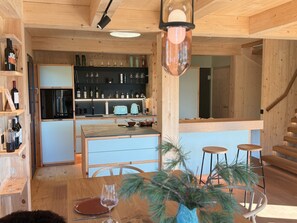 A wooden interior with a kitchen, dining area, and bar. - Deluxe Chalet With Sauna & hot tub (Stadl-Predlitz)