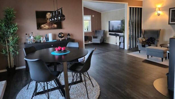 Un salon moderne comprenant un coin repas, un téléviseur à écran plat et une cheminée.