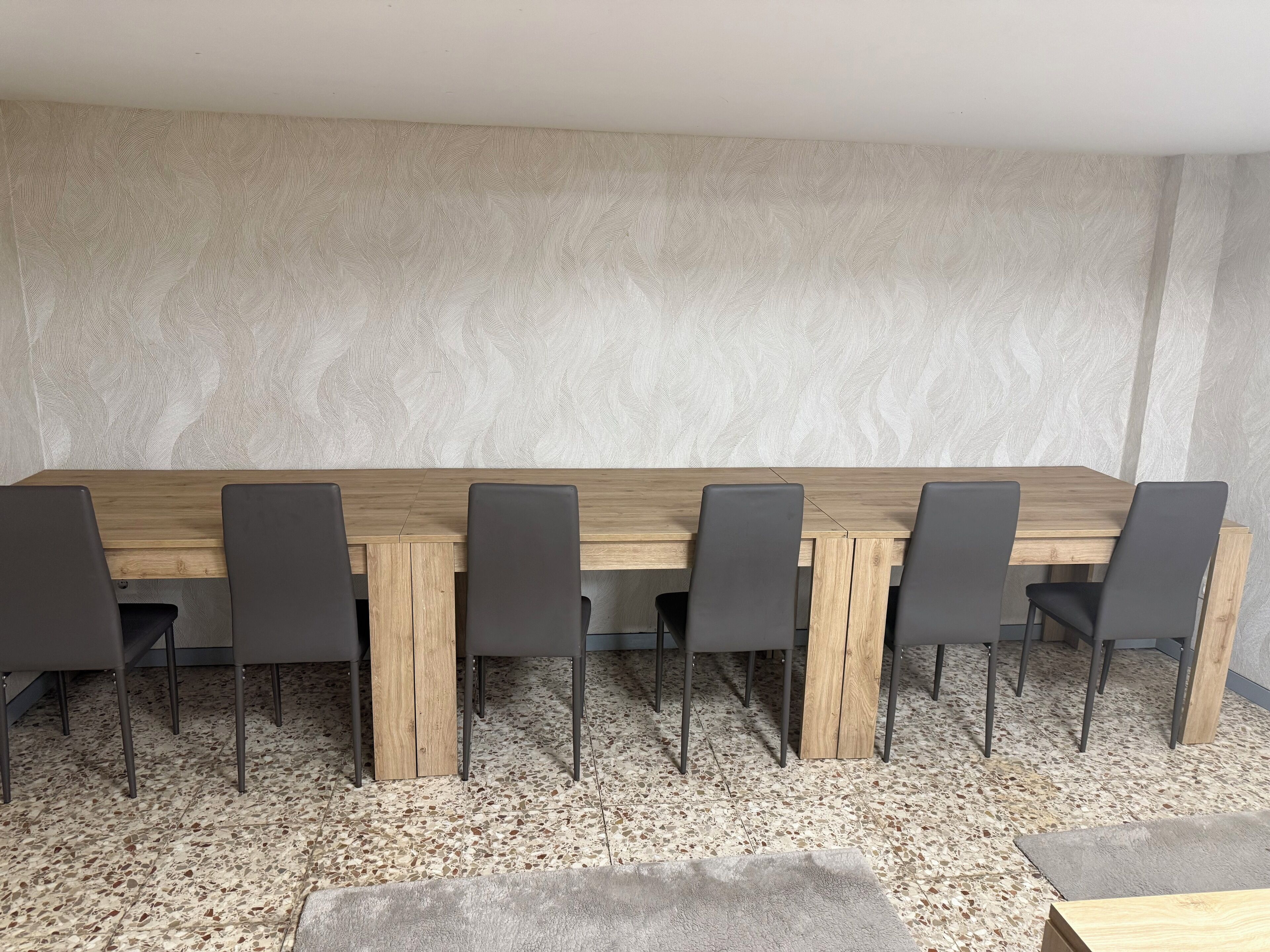 A conference room with a long wooden table and six chairs.