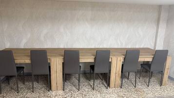 Una sala de conferencias con una larga mesa de madera y seis sillas.
