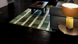 Ein modernes Wohnzimmer mit einer Couch, einem Couchtisch, einem Fernseher und einer Lampe.